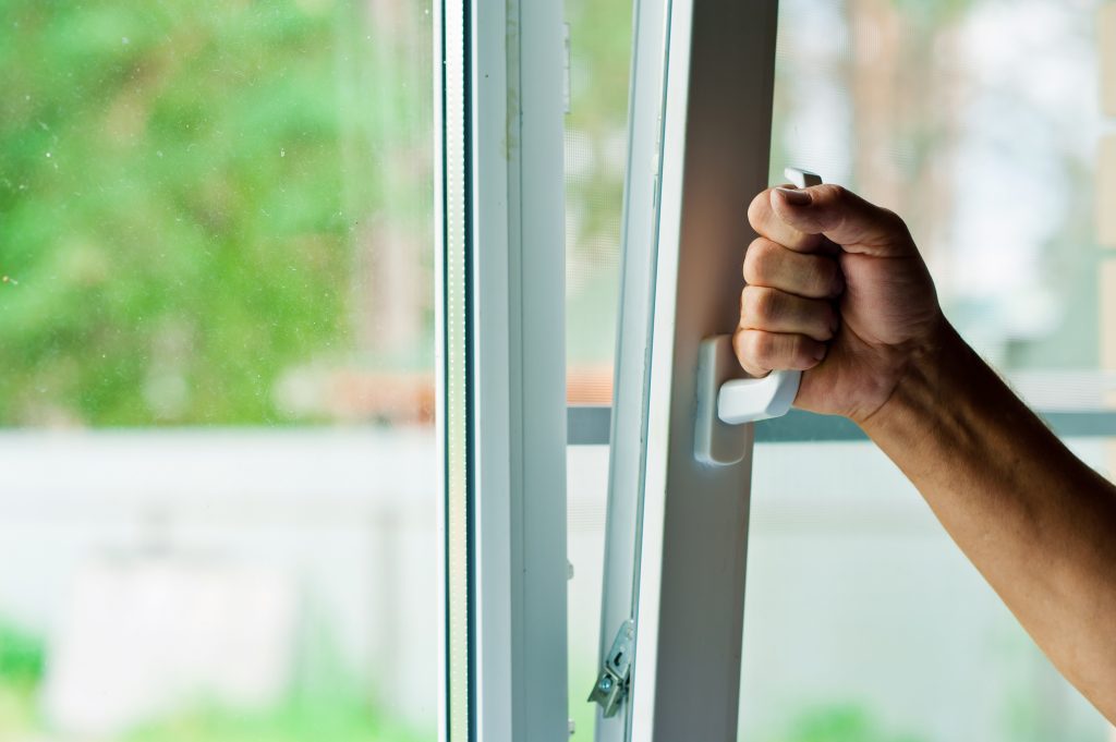 Image of hand opening a double-glazed window.